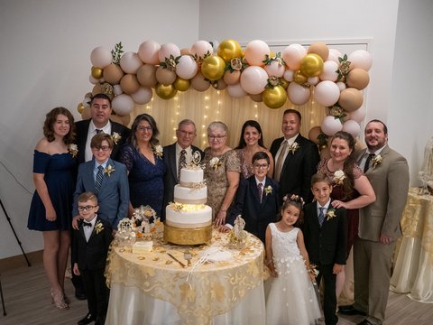 The Cardosos and their heirs standing behind the cake